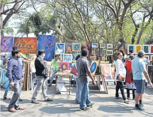  ?? AFP ?? This photo taken on January 15, 2017 shows Indian visitors walking through exhibition­s at the annual ‘Chitra Santhe’ art fair in Bangalore.