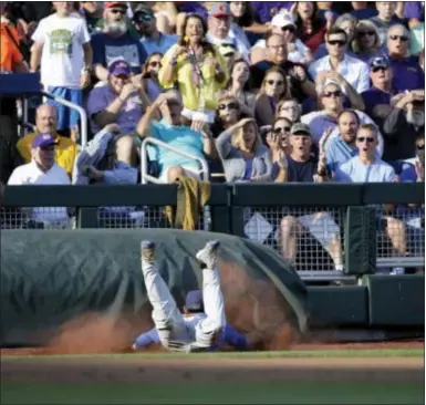  ?? NATI HARNIK — THE ASSOCIATED PRESS ?? Florida shortstop Dalton Guthrie, a Phillies draft pick, dives to catch a foul ball by LSU’s shortstop Kramer Robertson in the third inning of Game 1 of the NCAA College World Series finals in Omaha, Neb., Monday.