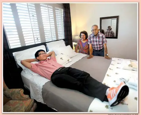  ?? TNS/ The Miami Herald/ MARSHA HALPER ?? Airbnb guest Gaofeng Zhang ( left) of Shenzhen City, China, stretches out in one of the three bedrooms Olimpia Yataco ( standing, left), 69, and Ismael Yataco, 76, rent via Airbnb. The Yatacos opened up their West Kendall, Fla., home to Airbnb guests...