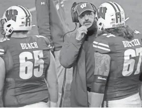  ?? MARK HOFFMAN / MILWAUKEE JOURNAL SENTINEL ?? Wisconsin offensive coordinato­r/offensive line coach Joe Rudolph (center) is pleased Jon Dietzen decided to return to the football team for his senior season.