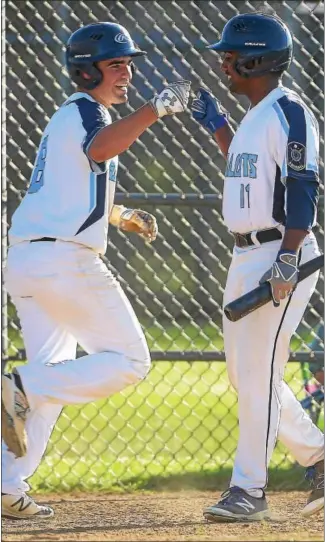  ?? PETE BANNAN — DIGITAL FIRST MEDIA ?? Lionville’s Mike Evans gets a fist bump from Justin George after scoring Monday night against Spring City. George had a bases-clearing double.