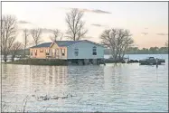  ?? [NATI HARNIK/ THE ASSOCIATED PRESS] ?? In this Oct. 22 photo, a home is surrounded by floodwater­s in Bartlett, Iowa.