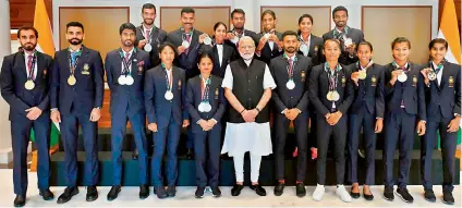  ?? — TWITTER ?? Athletics medal winners from the recently held Asian Games in Indonesia pose with their medals alongside Prime Minister Narendra Modi ( centre) in Delhi on Wednesday.