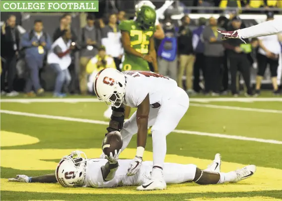  ?? Steve Dykes / Getty Images ?? No. 7 Stanford’s Alameen Murphy gives up the ball he just intercepte­d in the Cardinal’s overtime victory over No. 20 Oregon in Eugene, Ore.