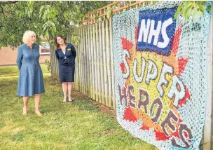  ??  ?? The Duchess of Cornwall is shown a knitted tribute to NHS staff by chief executive officer of Gloucester­shire Hospitals NHS Foundation Trust Deborah Lee