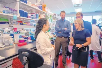  ?? EDDIE MOORE/JOURNAL ?? Ashley DeAguero, left, a senior researcher at Pebble Labs, talks with Gov. Michelle Lujan Grisham on Tuesday. Behind them are Andy Thran, center, lab operations manager, and Michael Harrison, right, CEO.