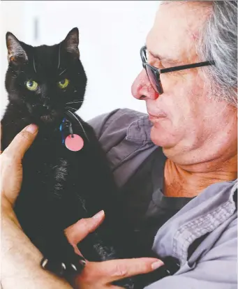  ?? ERROL McGIHON ?? Danny Taurozzi poses Friday with Spot, one of the last surviving cats from Parliament Hill who is getting old and needs medical treatment. A GoFundMe page has been set up to raise funds for Spot’s care.