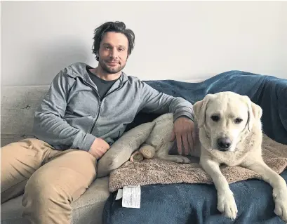  ?? TONY WONG TORONTO STAR ?? Dillon Casey at home in Toronto with his 2-year-old Labrador retriever, Rooney. “She’s been my therapy dog,” Casey says.