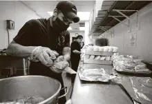  ?? Melissa Phillip / Staff photograph­er ?? Fulgencio Morales pulls tamales from a pot and wraps them by the dozen at Balderas Tamale Factory in Cy-Fair. The kitchen’s tamales are a holiday cult favorite.