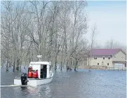  ??  ?? A boat ferries residents to Darlings Island, N.B., cut off by flood waters, on Sunday. Water levels are beginning to stabilize after reaching record levels on the weekend.