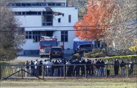  ?? NOAH K. MURRAY — THE ASSOCIATED PRESS ?? Authoritie­s gather Wednesday in Colts Neck, N.J., to investigat­e the aftermath of fatal fire that killed two children and two adults. Authoritie­s say two adults and two children were found dead the day before at the scene of a burning mansion near the New Jersey shore.