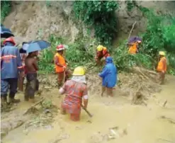  ?? — AFP ?? BANDARBAN: Bangladesh­i fire fighters search for bodies after a landslide in Bandarban yesterday.