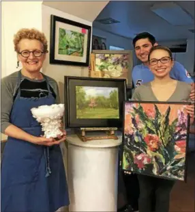  ?? SUBMITTED PHOTO — WHITEMARSH ART CENTER ?? Whitemarsh Art Center member Charlotte Martin, an award-winning potter, holds her porcelain and gold-leafed contributi­on to WAC’s 100 for 100 gala. Also shown are oil paintings donated to the fundraiser by local artists Theresa Rooney, Susan Gold and...