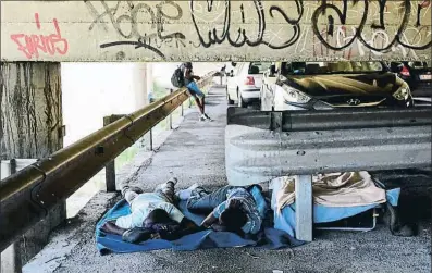  ?? MIGUEL MEDINA / AFP ?? Immigrants dormint sota un pont a Ventimigli­a (Itàlia), al costat de la frontera amb França