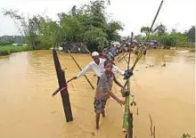  ?? AFP ?? Rohingya refugees cross flood waters at Thangkhali refugee camp in Bangladesh’s Cox’s Bazar district yesterday.