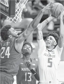  ?? MICHAELHIC­KEY/GETTY ?? Maryland’s Donta Scott reaches to block Illinois’ Andre Curbelo during the second half Sunday at State Farm Center in Champaign, Illinois.