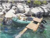  ??  ?? Top: A diver from the nonprofit Clean Up the Lake collects debris in Lake Tahoe. Above: Divers move a large piece of junk to a floating trash raft named Darlene.