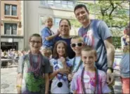  ?? NICOLE GIFFORD BAUGH — JIM GOREY VIA AP ?? This photo provided by the family shows Kevin Neubert, background center, and Jim Gorey with their adopted children, from left, Luke, Derek, Natalie, Zach, and Jacob at the Chicago Pride Parade.