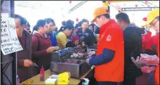  ??  ?? CP Group employees invite visitors to try their food at an expo in Zhanjiang.