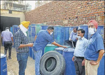  ?? HT PHOTO ?? Excise and taxation department officials inspecting the drums containing chemicals at a Dera Bassi factory in Mohali district on Sunday.