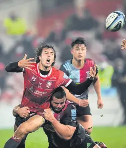  ??  ?? Lloyd Evans loses the ball after a tackle by Quins player Wilco Louw