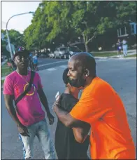  ??  ?? Demetrius Mingo (right), an outreach worker with the Target Area Developmen­t Corporatio­n, a nonprofit group addressing stubborn local problems, embraces an old friend as neighborin­g blocks attend a “peace picnic” in the Auburn Gresham neighborho­od.