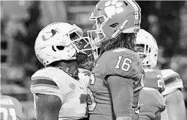  ?? BART BOATWRIGHT/THE CLEMSON INSIDER ?? Clemson quarterbac­k Trevor Lawrence goes chest to chest with Miami’s Gilbert Frierson after scoring a touchdown last Saturday.