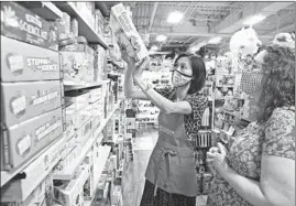  ?? STACEY WESCOTT/CHICAGO TRIBUNE ?? Katherine Nguyen, left, owner of Building Blocks Toy Store in Chicago, helps shopper Erica Ozbek find a gift for a toddler at the store on Aug. 31.