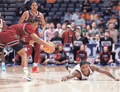  ?? ALAN POIZNER/FOR THE TENNESSEAN ?? South Carolina’s Meechie Johnson (5) grabs a loose ball as Auburn’s K.D. Johnson dives for it during their quarterfin­al game of the SEC Tournament on Friday at Bridgeston­e Arena in Nashville, Tenn.