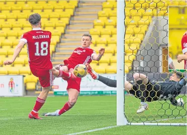  ??  ?? Calum Hendry bundles the ball past Livi keeper Max Stryjek for Aberdeen’s opener