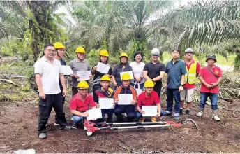  ?? ?? Participan­ts of the ‘Advanced Oil Palm Cutting Usage and Maintenanc­e’ pose with the centre’s officials upon the completion of their short course.
