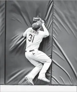  ?? Denis Poroy Getty Images ?? JOC PEDERSON slams into the center-field wall after running down a line drive by San Diego’s Justin Upton and making a backhanded catch over his head.