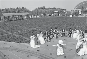  ?? XINHUA ?? Musicians play at a flower field in Nansha Free Trade Zone, Guangdong province, while a robot dances to their tunes.