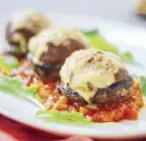  ??  ?? Stuffed mushrooms with tomato basil salsa: The Plaza burger shaped into meatballs and placeD on the bottom of a mushroom, baked till cooked with melted cheese on top.