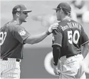  ?? JOHN BAZEMORE/AP ?? Tim Tebow, left and Miami Marlins center fielder Matt den Dekker chat before the game Monday. Tebow and den Dekker both attended UF at the same time.