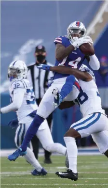  ?? GETTY IMAGES ?? IN TRAFFIC: Buffalo’s Stefon Diggs catches a pass as Indianapol­is’ T.J. Carrie delivers a hit during the second half as the Bills picked up a 27-24 victory Saturday.