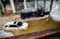  ?? Marie D. De Jesús / Staff photograph­er ?? A Houston police water rescue vehicle moves past a flooded vehicle Tuesday on Houston Avenue.