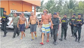  ??  ?? HEADING HOME: Russian Sergei Polonsky, centre, is escorted by Cambodian military police off an island in Preah Sihanouk province on May 15 before being deported.