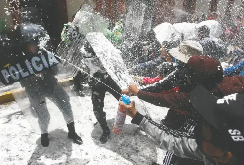  ?? JUAN CARLOS CISNEROS / AFP VIA GETTY IMAGES FILES ?? People marching in honour of those who died during clashes with police during demonstrat­ions against Peruvian
President Dina Boluarte, stop and spray police with foam and water as a carnival tradition in Puno, Peru.