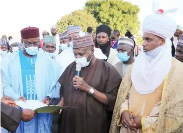  ??  ?? Gov. Muhammadu Inuwa Yahaya (middle) hands over title document and signature plan of a 5.4-hectare land to the Nigeria National Petroleum Corporatio­n’s Group General Manager, Engr. Abdullahi Bomai (left), on behalf of the corporatio­n, for the constructi­on of a 200-bed capacity Hospital in Gombe at the weekend. With them is the Emir of Gona, Alhaji Umar Bappah Abdulkadir (right)