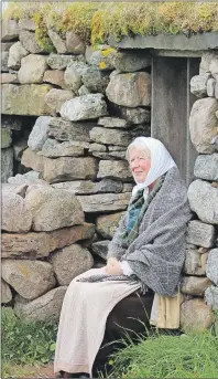  ??  ?? RIGHT: Aileen MacLean is shown sitting outside the Black House at the Nova Scotia Highland Village, Hector’s Point in Iona.