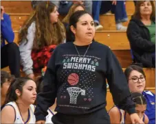  ?? JEANS PINEDA/Taos News ?? TOP: Analise MacAuley, left, contest the jumpshot on Wednesday (Dec. 21). BOTTOM: Coach Mandy Montoya sports a ‘Merry Swishmas’ ugly Christmas sweater for last week’s game — a gift, she said, from her mother.