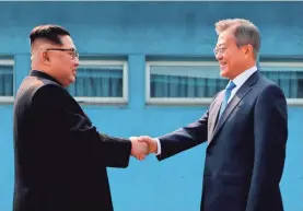  ?? POOL PHOTO BY AFP/GETTY IMAGES ?? North Korea’s Kim Jong Un, left, and South Korea’s Moon Jae-in meet April 27 at the border that divides their countries.