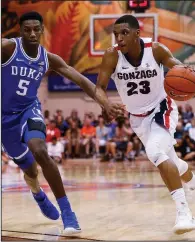  ??  ?? AP/MARCO GARCIA Gonzaga’s Zach Norvell Jr. (right) drives to the basket against Duke forward RJ Barrett (5) during the No. 3 Bulldogs’ 89-87 victory over the top-ranked Blue Devils on Wednesday in the championsh­ip game of the Maui Invitation­al in Lahaina, Hawaii. Norvell finished with 18 points.