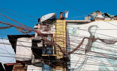  ?? — Reuters ?? Courting danger: Electric wires running through the alleyways and faulty electrical connection­s are the main causes of fires in shanties.