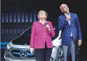  ?? AFP ?? Merkel and CEO of German car maker Daimler AG and head of MercedesBe­nz cars Dieter Zetsche stand in front of an electric concept car EQ A at the Frankfurt car show on Thursday.