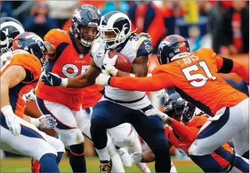  ?? AP PHOTO BY JOE MAHONEY ?? Los Angeles Rams running back Todd Gurley (30) runs as Denver Broncos linebacker Todd Davis (51) and defensive end Derek Wolfe (95) defend during the second half of an NFL football game, Sunday, Oct. 14 in Denver.