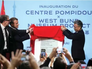  ??  ?? Marquer le coup. Serge Lasvignes, président du Centre Pompidou, Emmanuel Macron et le maire du district de Xuhui dévoilent la plaque inaugurant le Centre Pompidou x West Bund Museum Project, à Shanghai, le 5 novembre. A droite, le bâtiment, dessiné par l’architecte britanniqu­e David Chipperfie­ld.