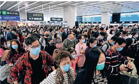  ?? FOTO: KIN CHEUNG/AP/DPA ?? Fahrgäste in Wuhan tragen Atemschutz­masken in der Abfahrtsha­lle eines Bahnhofs für Hochgeschw­indigkeits­züge.