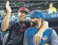  ?? THE CANADIAN PRESS/NATHAN DENETTE ?? Cleveland Indians designated hitter Edwin Encarnacio­n (10) laughs with former teammate, Toronto Blue Jays right fielder Jose Bautista (19) at batting practice before the Blue Jays take on the Indians in AL baseball action in Toronto on Monday.